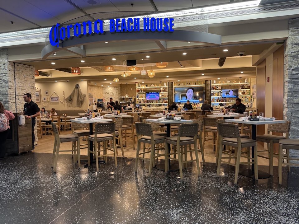Airport dining room with tables and warm lighting.